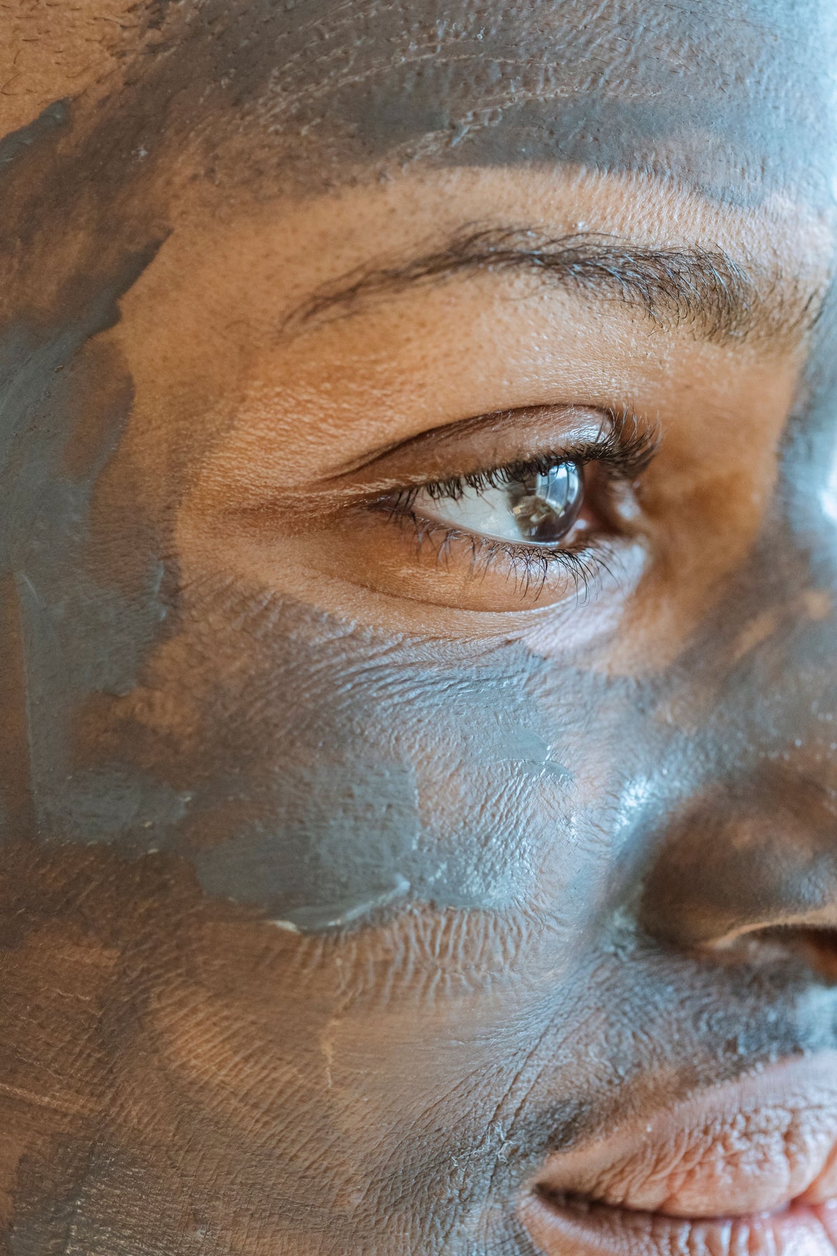 DÉSIR — Femme africaine américaine masque argile sur le visage, pores propres, teint net